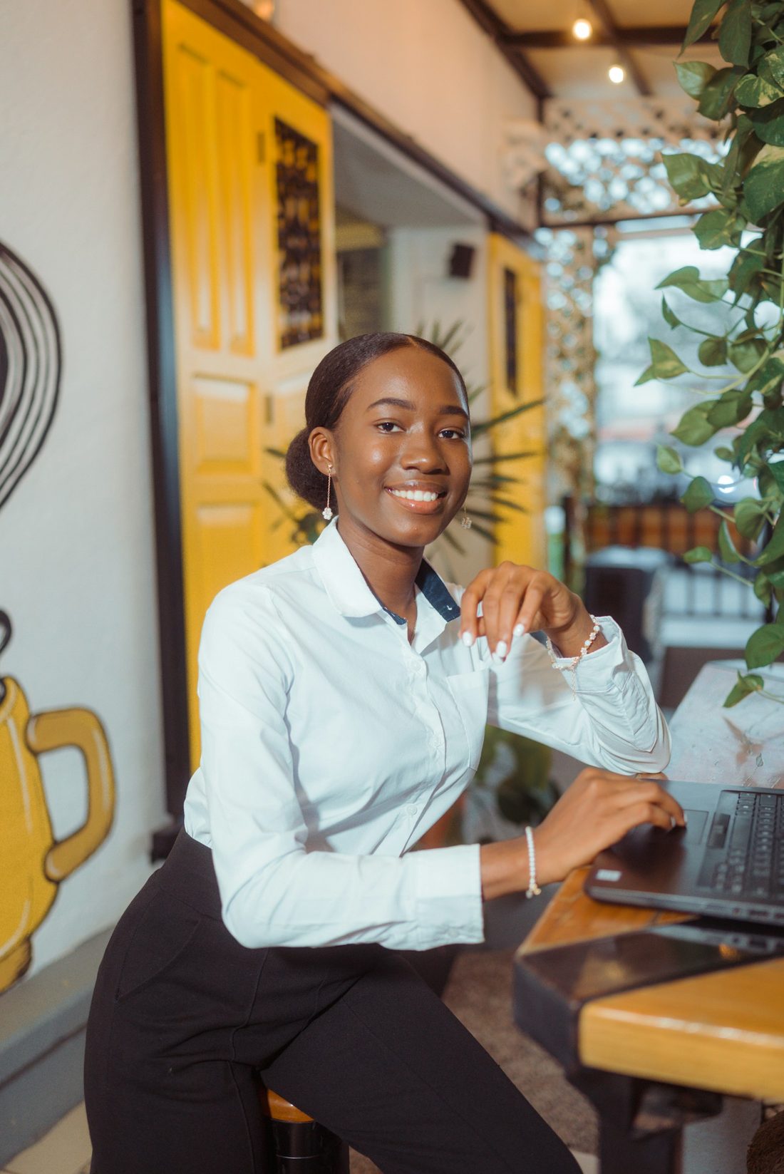 Empreendedora sorrindo enquanto resolve as contas no laptop